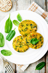 Quinoa spinach chickpeas pumpkin fritters on a wood background