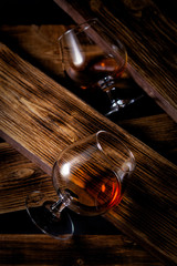 glasses of whiskey or cognac on a wooden background