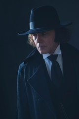 Fototapeta na wymiar Mysterious victorian man in black coat and hat.