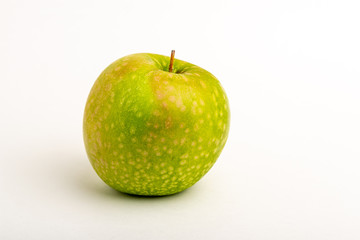 Green ripe apple close up on a white background