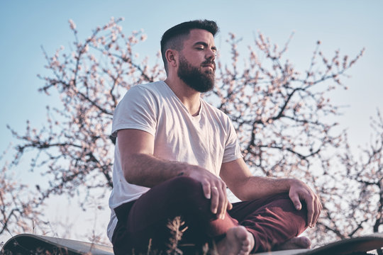 Bearded man meditating in spring garden