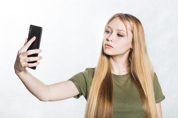 Beautiful young woman taking selfie on smartphone.