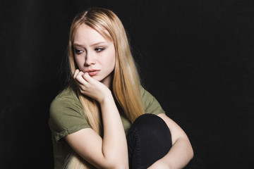 Fototapeta premium Sad young woman going to cry in a black background