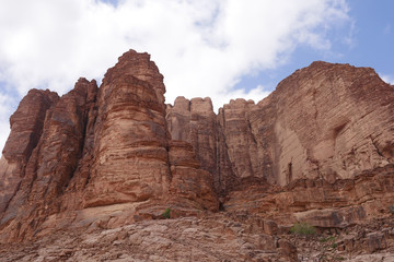 Felslandschaften im roten Wüstensand des Wadi Rum mit Verwehungen an Steinen