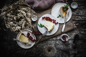 From above cheese cake pieces served on plate with berry on dark wooden table