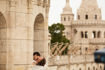 Young beautiful stylish pair of newlyweds kissing by the Fisherman's Bastion in Budapest, Hungary