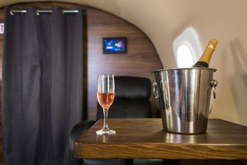 A glass of champagne in the interior of a private jet. Flying first class