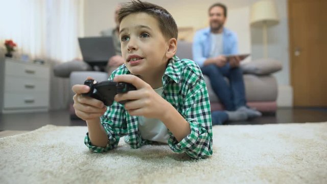 Preteen boy playing video game, dad and granddad smiling, leisure and hobby