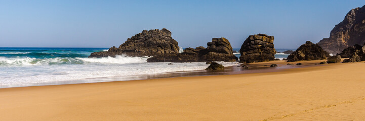 Fototapeta na wymiar View of Adraga sandy beach with stones near Sintra, Portugal's rocky coast