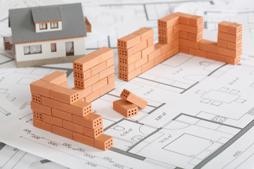 Model house construction with brick on blueprint