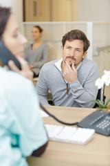 male patient with doctor at reception desk in hospital