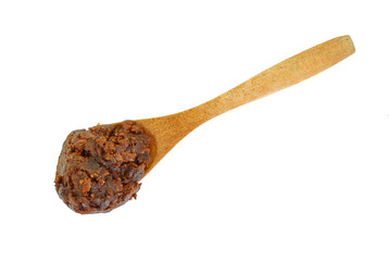 Miso paste in wooden spoon isolated on white.