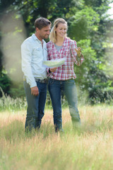 couple in casual outfit looking at compass and map
