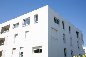 Modern white apartment buildings on a sunny day with a blue sky