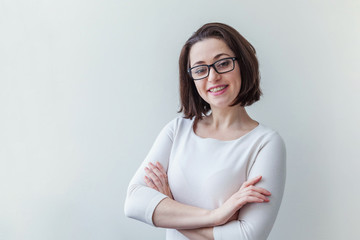 Obraz premium Beautiful happy girl smiling. Beauty simple portrait young smiling brunette woman in eyeglasses isolated on white background. Positive human emotion facial expression body language. Copy space