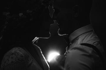 Silhouette of the guy and girl face to face. dark background and