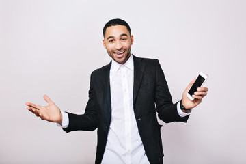 Achievement great results at work, success in career of handsome young man in white shirt, black jacket expressing happiness on white background. Stylish businessman, joy, smiling, positivity