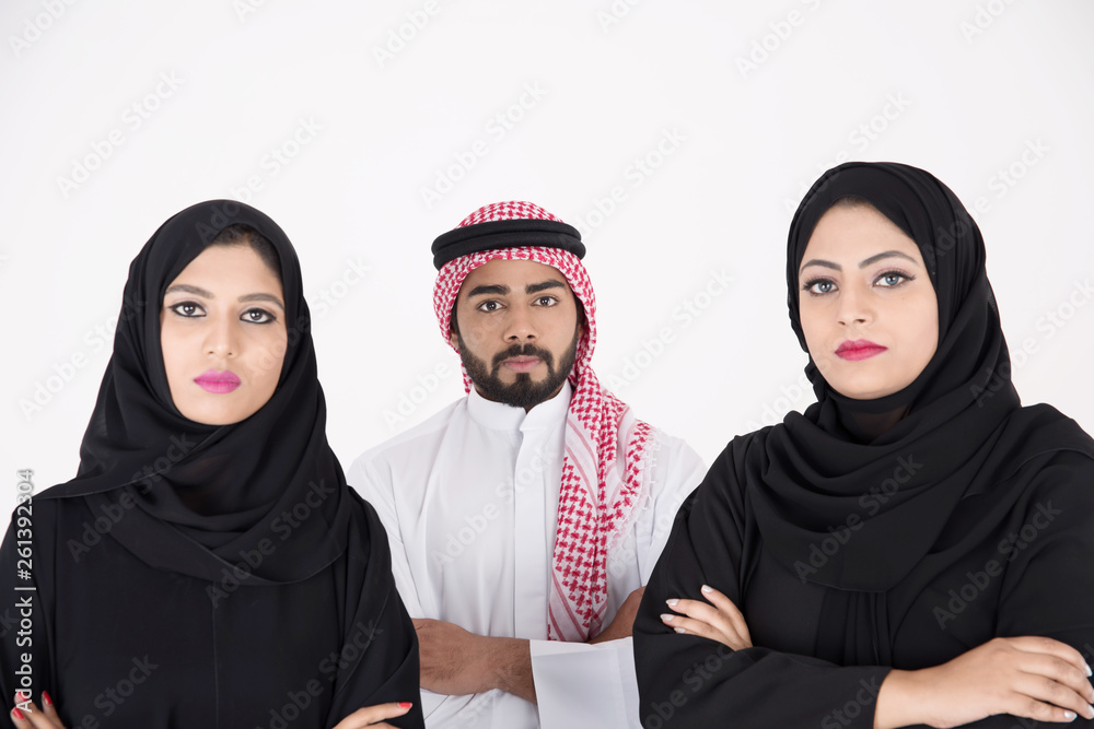 Wall mural two arab females with one male smiling and standing on white background