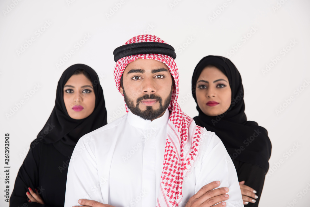 Wall mural two arab females with one male smiling and standing on white background