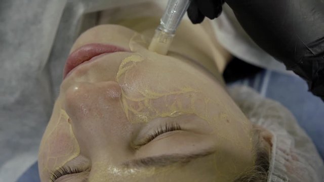 middle aged woman is lying in beauty salon during procedure of bb glow treatment for face, close-up