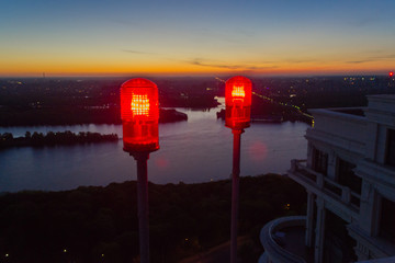 red warning light on the roof of the house at sunrise