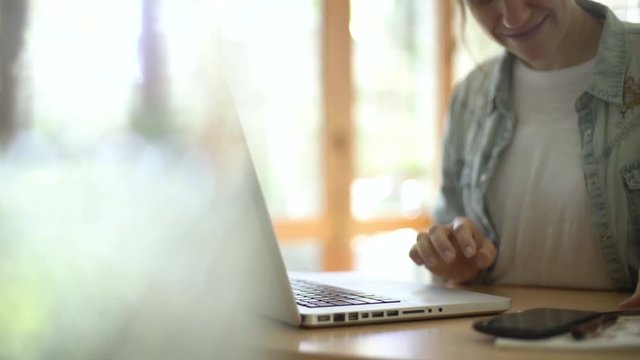 Mid section of cheerful mature woman using a laptop while making online payment through credit card at home