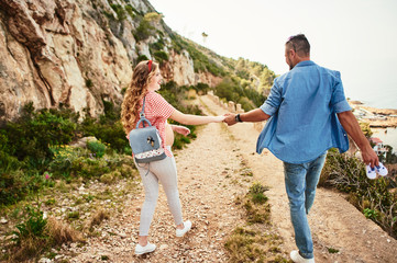 Young pregnant woman posing with her husband with sea on background