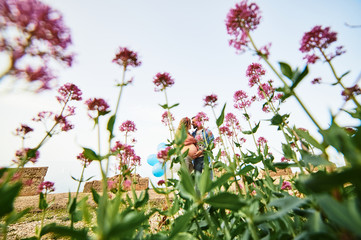 Young healthy beauty pregnant woman with her husband and balloons outdoors
