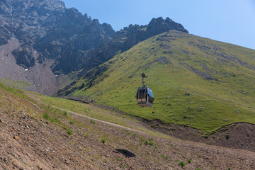 the cab of a cable car rises to the top of the mountain