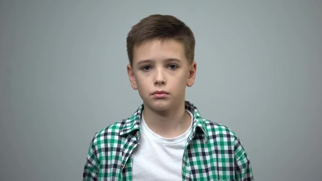 Preteen boy looking to camera, orphan social care, domestic violence prevention