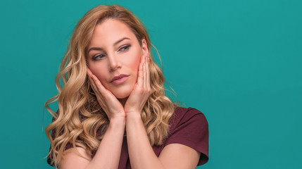Fototapeta premium Young attractive blonde on a blue background.