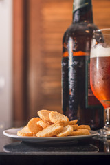 Little chips along with a beer bottle and glass