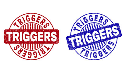 Grunge TRIGGERS round stamp seals isolated on a white background. Round seals with grunge texture in red and blue colors. Vector rubber watermark of TRIGGERS text inside circle form with stripes.