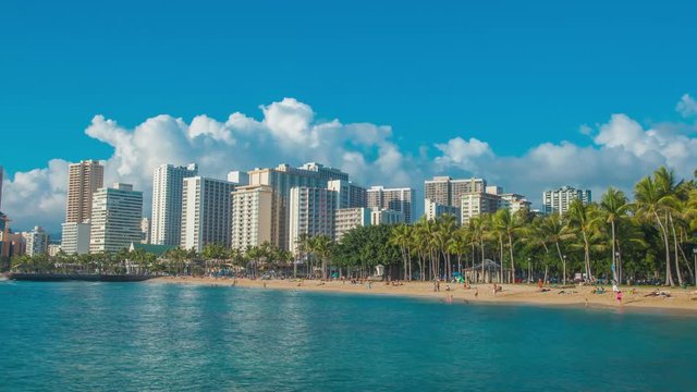 4K Cinematic urban time lapse in motion dynamic video view of the beach and hotels in Honolulu Hawaii with dramatic clouds in the background