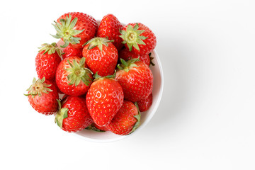 Strawberries in a white bowl isolated on white background, top view