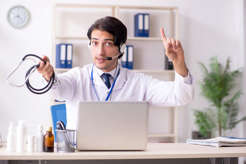 Young male doctor in telemedicine concept 