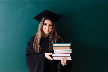 Female graduate student in front of green board 