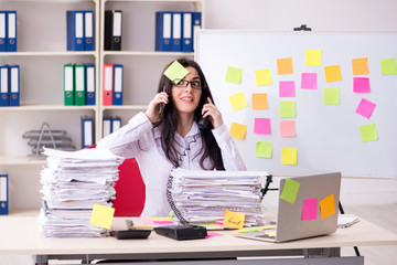 Young female employee in conflicting priorities concept 