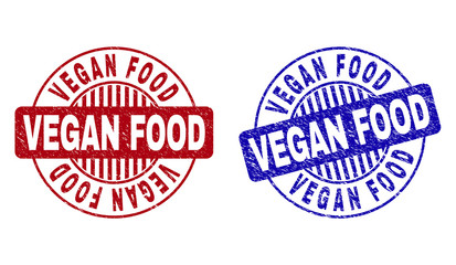 Grunge VEGAN FOOD round stamp seals isolated on a white background. Round seals with grunge texture in red and blue colors. Vector rubber overlay of VEGAN FOOD caption inside circle form with stripes.