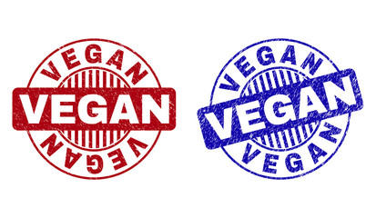 Grunge VEGAN round stamp seals isolated on a white background. Round seals with distress texture in red and blue colors. Vector rubber watermark of VEGAN label inside circle form with stripes.