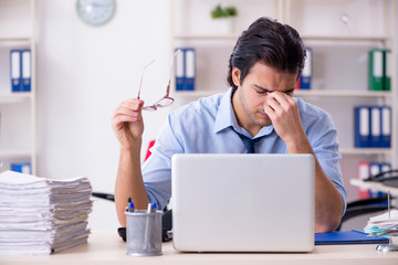 Young male businessman employee unhappy with excessive work  