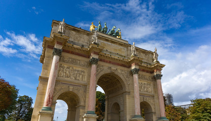 Fototapeta na wymiar Low angle view of Arc de Triomphe du Carrousel in cloudy blue sky day