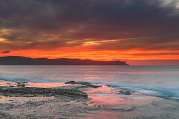 Fototapeta premium Orange Lights the Sky Cloudy Sunrise Seascape