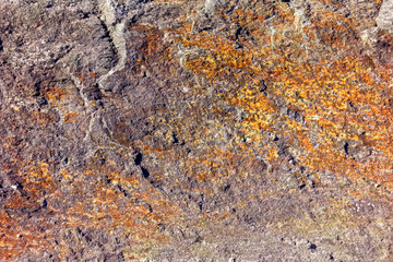 Brown stone wall rock texture background close-up.