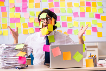 Young employee in conflicting priorities concept 