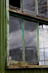 Dilapidated wooden window frame on condemned derelict factory building awaiting demolition 