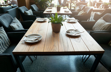 empty wooden table at restaurant and white plate on table .