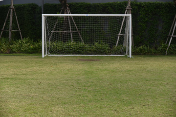 Football /soccer goal gate  with net and green lawn grass background in view behind