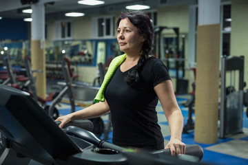 Senior woman at the gym walks on a treadmill. close-up. copy space.