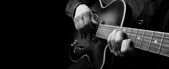 Zelfklevend Fotobehang Guitarist hands and guitar close up. playing electric guitar. copy spaces.  black and white. © Oleksii